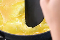 鮮蔬梅棗潤餅作法4：表面膨脹處撮破，蛋液微乾再翻面